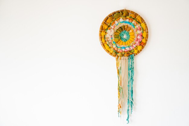 Dream catcher woven with wool on a white wall with copy space