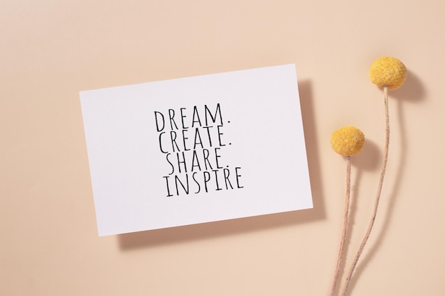 Photo dream create share inspire words written on card invitation card with craspedia flowers on beige background