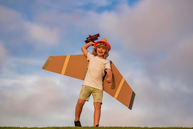 Dream of flying Little children with toy airplane in a field at sunset Success and child leader concept Boy dreams of becoming a pilot