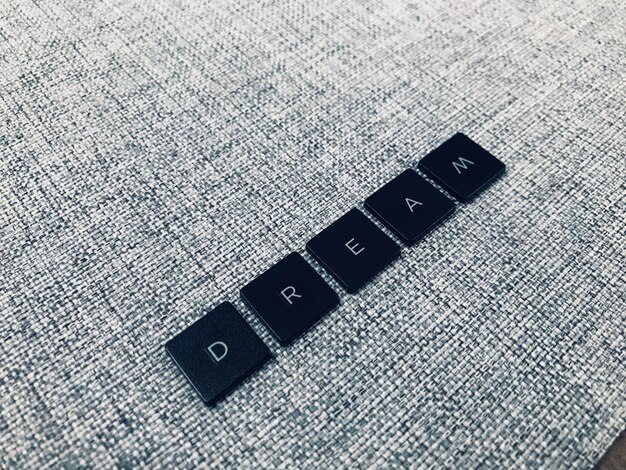 Photo dream word made of black square letters on grey fabric background