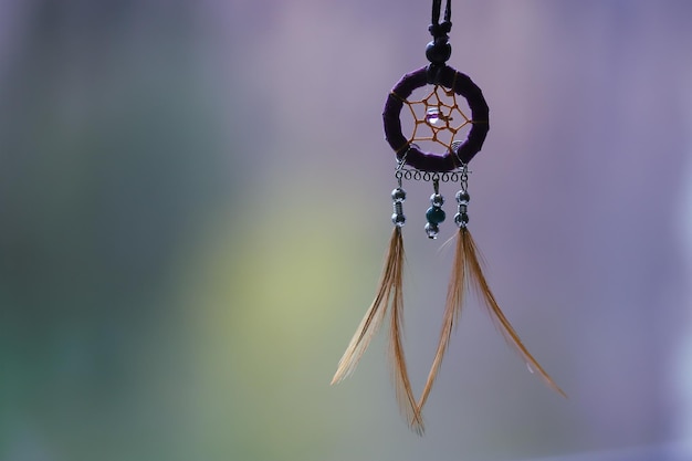 Photo dreamcatcher on a colored blurred background dark silhouette