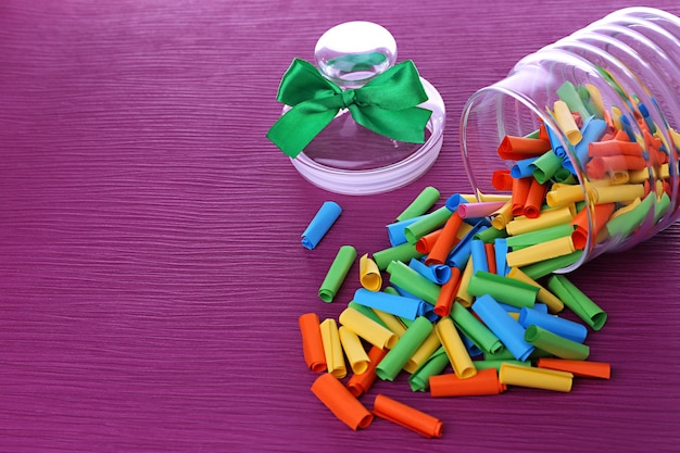 Dreams written on color  rolled paper in glass jar, on color background