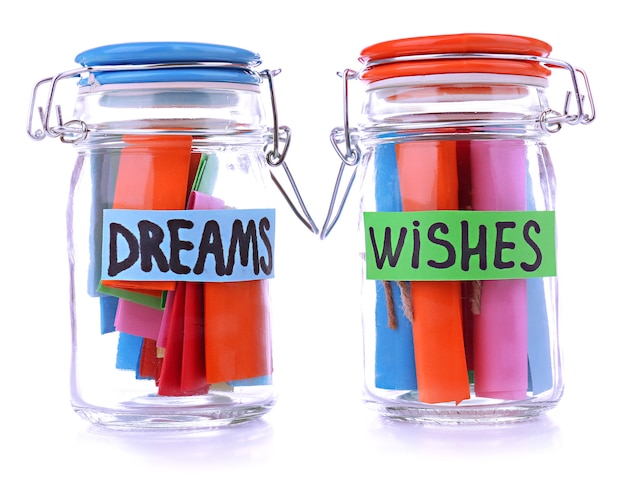 Dreams written on color  rolled paper in glass jar, isolated on white