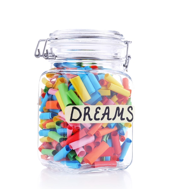 Dreams written on color  rolled paper in glass jar, isolated on white