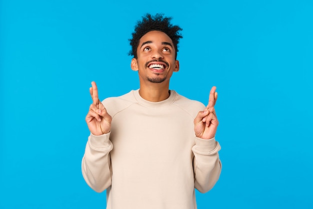 Dreamy excited and happy young man contemplate wonderful fireworks on new year holiday, watching entertaining scene. Attractive african american guy looking and pointing up, smiling happily