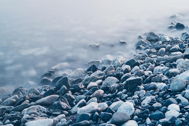 Dreamy natural background with sea shore rocks and waves Long exposure