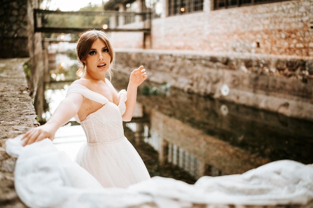Foto ritratti da sogno di bella sposa sulla riva del fiume di pietra