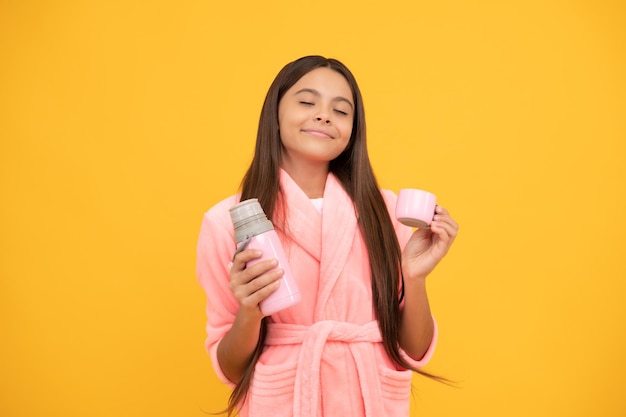 dreamy teen girl in home terry bathrobe with thermos bottle, daydreamer.