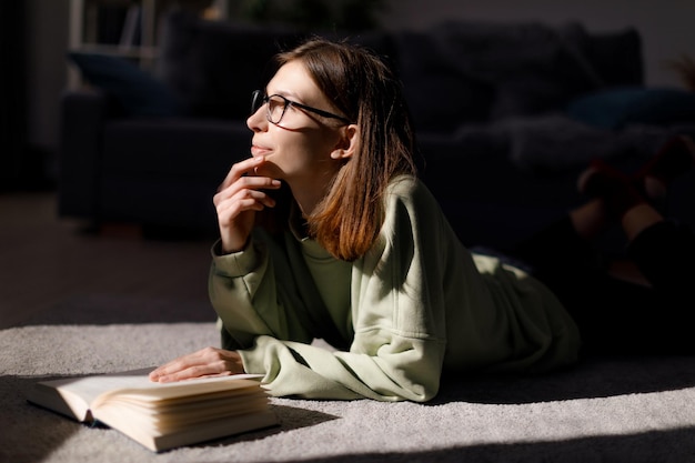 Dreamy woman reading book