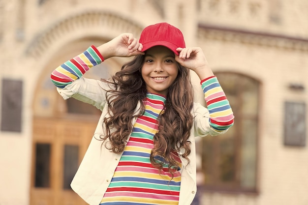 Dress like real hipster Happy child enjoy hipster style Little hipster wear baseball cap outdoors Hipster look of small girl Fashion accessory Trendy style Streetwear Funky beauty