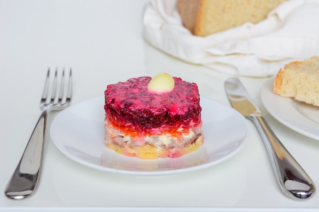 Dressed herring or herring under a fur coat. Traditional Russian cuisine. Layered salad composed of diced pickled herring covered with layers of boiled grated vegetables and mayonnaise.