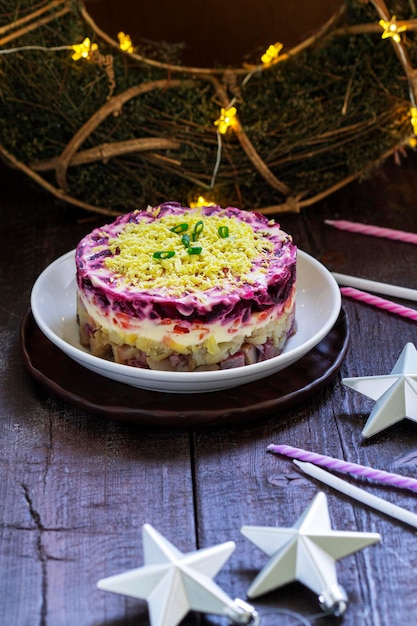 Photo dressed herring raditional soviet festive salad of herring and vegetables in a new years decoration