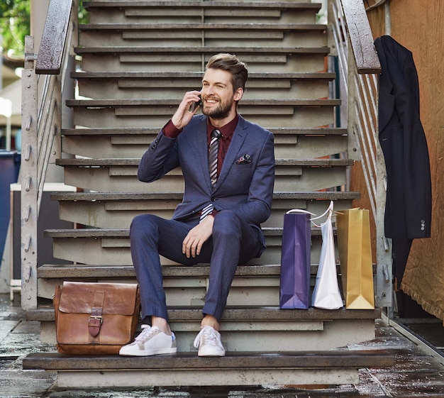 Dressed in his best for a day of retail therapy Shot of a well dressed young man using his phone on a shopping spree