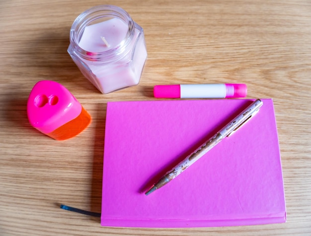 On the dressing table notebook pen candle all in pink tone