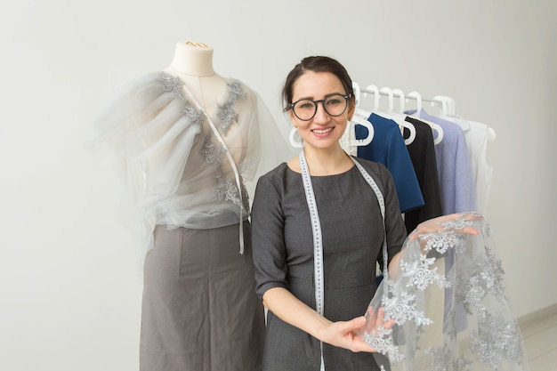 Sarto da donna, stilista, sarto e concetto di persone - stilista di giovane donna in lei