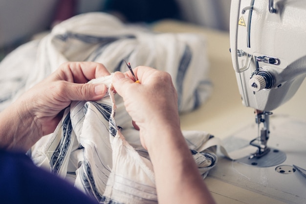 The dressmaker sews at the sewing machine