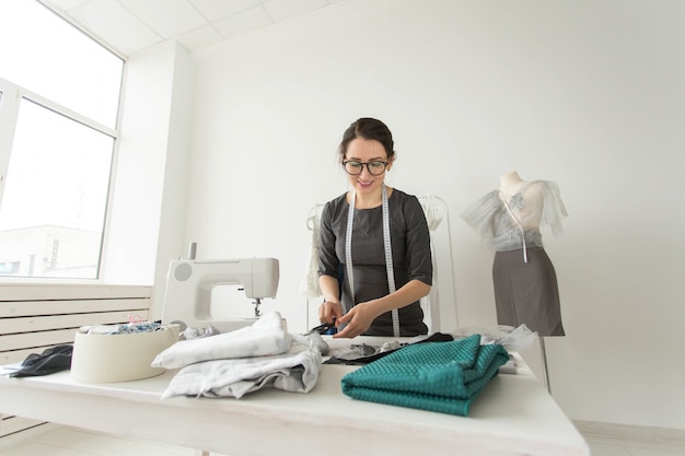 Dressmaker, tailor, fashion and showroom concept - Portrait of talented female dressmaker working with textile for sewing clothes.