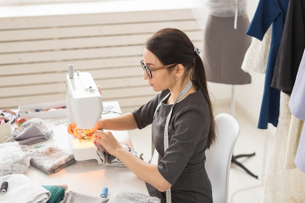 Dressmaker tailor and seamstress concept  young fashion designer working in her showroom