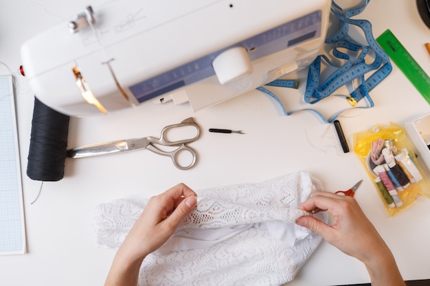 Dressmaker working with white cloth