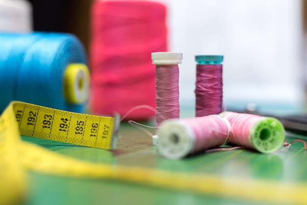 Photo dressmaker workshop close up of measuring tape and sewing thread needles and thread