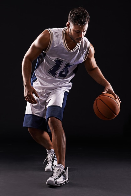 dribbling pro studio shot of a basketball player against a black background