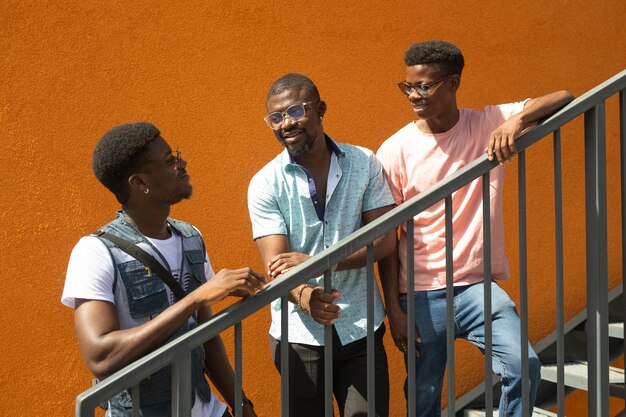 drie Afrikaanse jonge mannen op oranje achtergrond