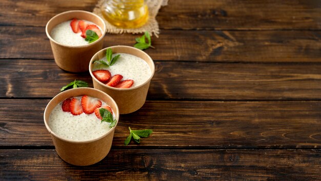 Drie ambachtelijke papieren bekers met tapiocapudding met plantaardige melk