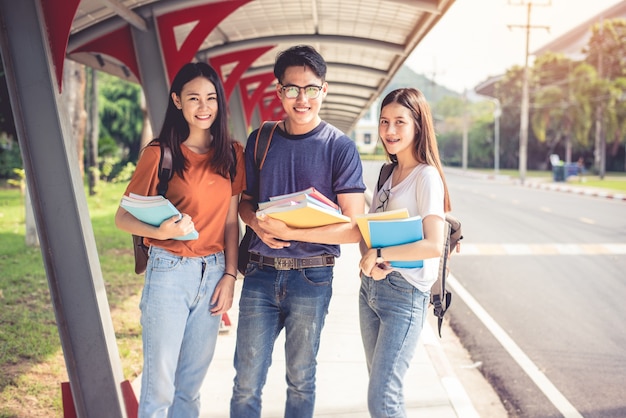 Drie Aziatische jonge campusstudenten genieten samen van tutoring en boeken lezen