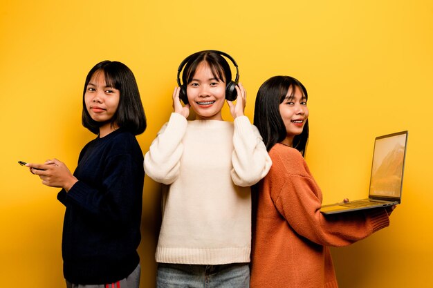 Drie Aziatische vrouwen die tegelijkertijd met laptop en telefoon werkten