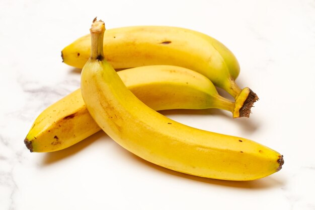 Foto drie bananen op een witte en grijze marmeren keukentafel in een close-up view