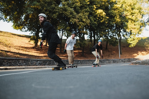 Drie charismatische jongens rijden op longboards. Onderaanzicht. Hoge kwaliteit foto