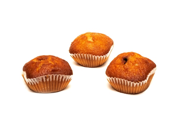 Drie chocolademuffins die op witte achtergrond worden geïsoleerd