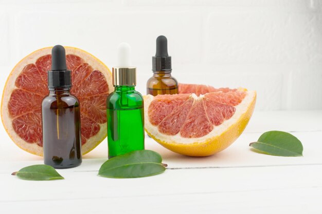 Drie cosmetische flaons met grapefruitolie voor schoonheid, huidverzorging, welzijn. alternatief medicijn.