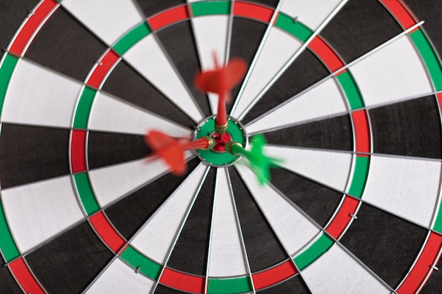 Drie darts raken rood doel op het doel juist close-up