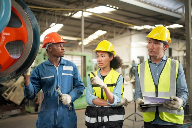 Drie diverse multiculturele ingenieurs en arbeiders in de zware industrie in uniform bij Steel Factory