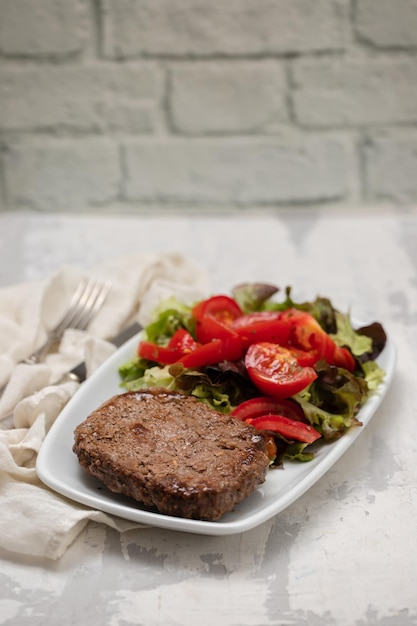 Drie gebakken gehakt met verse salade op witte plaat