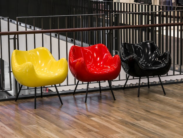 Drie gekleurde stoelen staan in het winkelcentrum