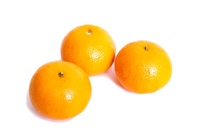 Drie gele mandarijnen die op witte achtergrond worden geïsoleerd