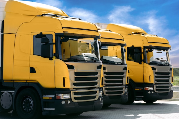 Drie gele vrachtwagens van een transportbedrijf