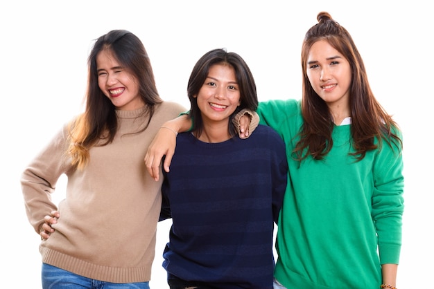 drie gelukkige jonge Aziatische vrouw vrienden lachend samen met armen op schouders