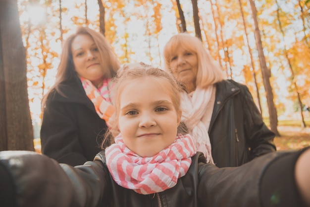 Drie generaties vrouwen en honden vinden het leuk om samen naar de camera te kijken die poseert voor een zelfportretfoto