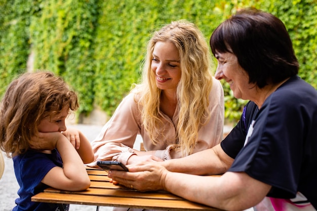 Drie generaties vrouwen zitten op het terras van een café