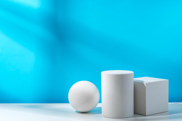 Drie geometrische vormen op een tafel tegen een helderblauwe achtergrond bij dagverlichting