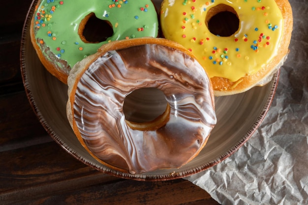 Drie gestapelde donuts op plaat Chocolade Geel Groen Bovenaanzicht