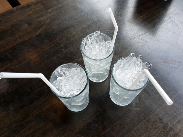 Foto drie glazen ijs met een rietje op tafel