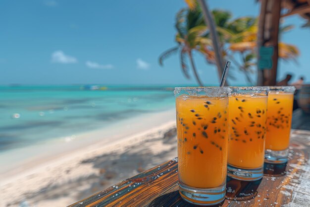 Drie glazen sinaasappelsap op een strandtafel onder de lucht.