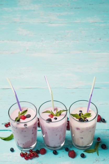 Drie glazen verschillende verse bessen smoothies met kopie ruimte