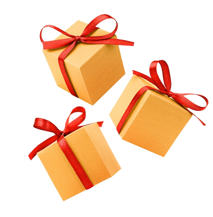 Foto drie gouden geschenkdozen met rode strik op geïsoleerde witte achtergrond