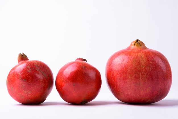 Drie Granaatappels Op Een Geïsoleerde Rij