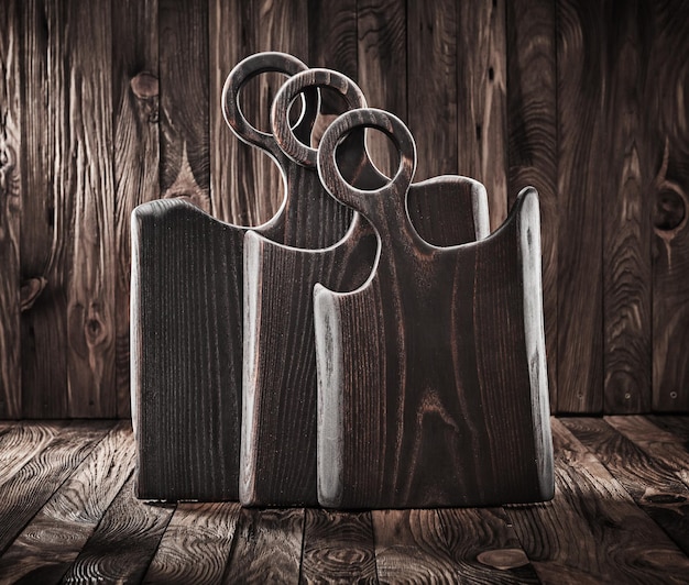 Drie handgemaakte keuken houten snijplanken op vintage achtergrond